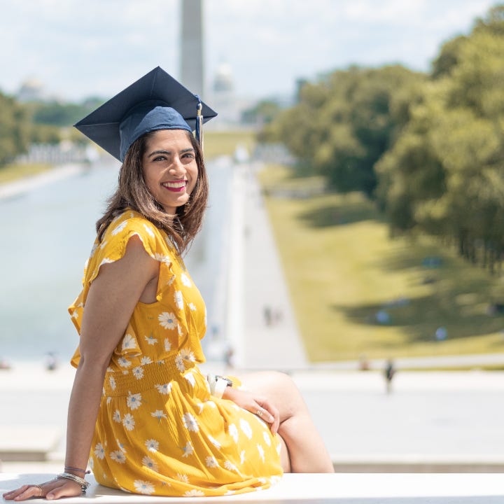 A graduating student sits on the steps overlooking the west mall in Washington DC